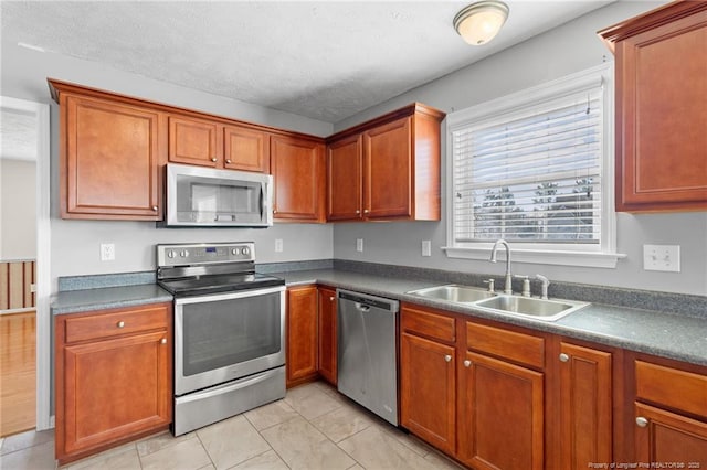 kitchen featuring appliances with stainless steel finishes, light tile patterned flooring, and sink