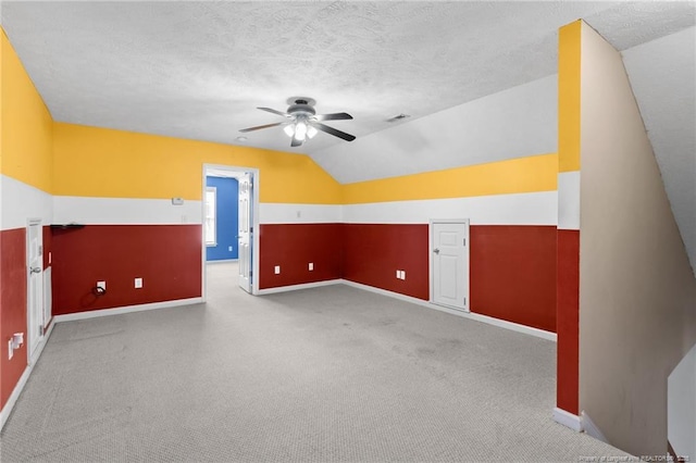 bonus room with ceiling fan, a textured ceiling, carpet floors, and vaulted ceiling