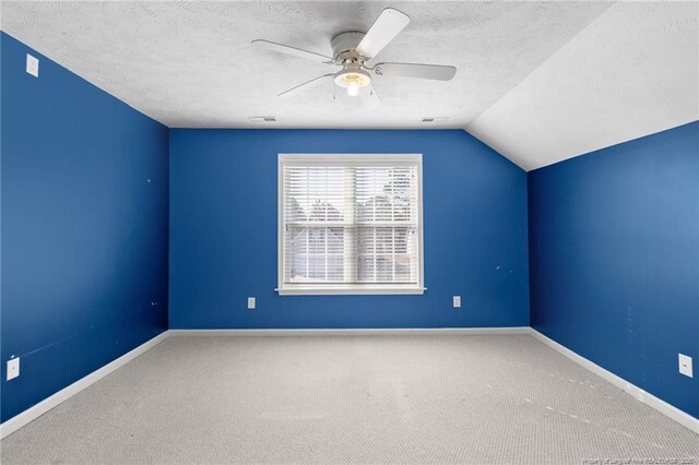 additional living space featuring a textured ceiling, ceiling fan, vaulted ceiling, and carpet flooring