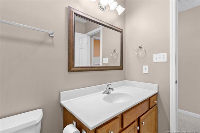 bathroom with a textured ceiling, vanity, and toilet