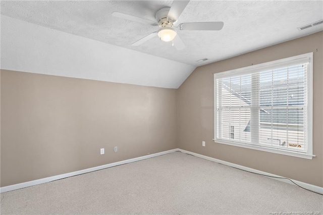 additional living space featuring lofted ceiling, a textured ceiling, ceiling fan, and carpet