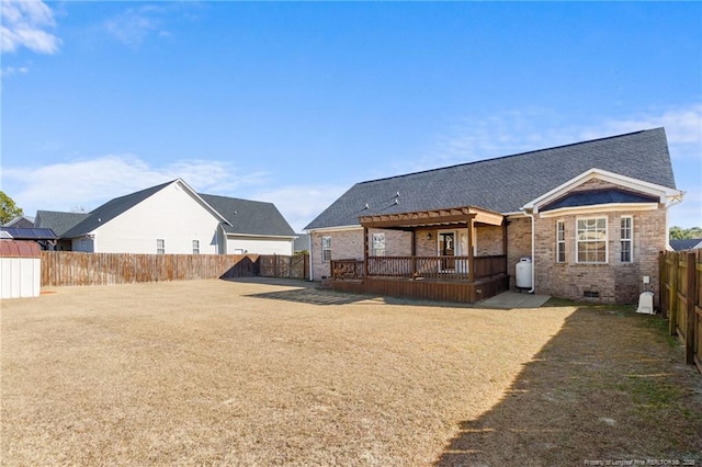 back of property featuring a wooden deck and a lawn