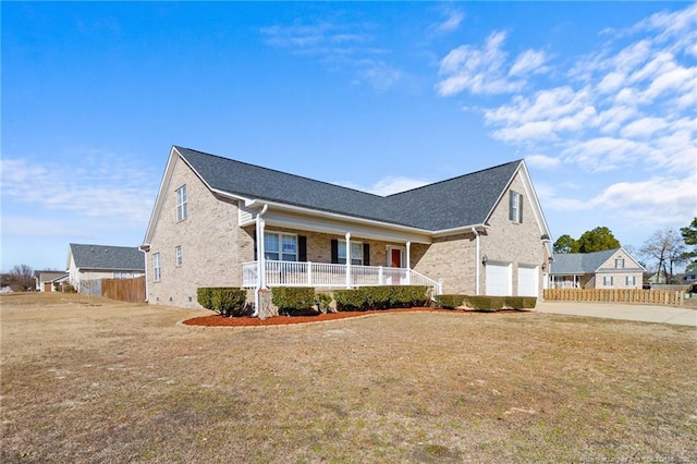 view of front of property featuring covered porch, a front lawn, and a garage