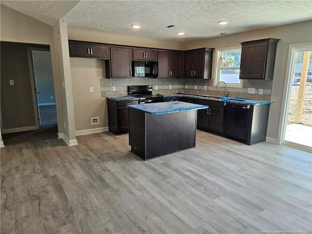 kitchen with dark brown cabinetry, a sink, light wood-type flooring, black appliances, and tasteful backsplash