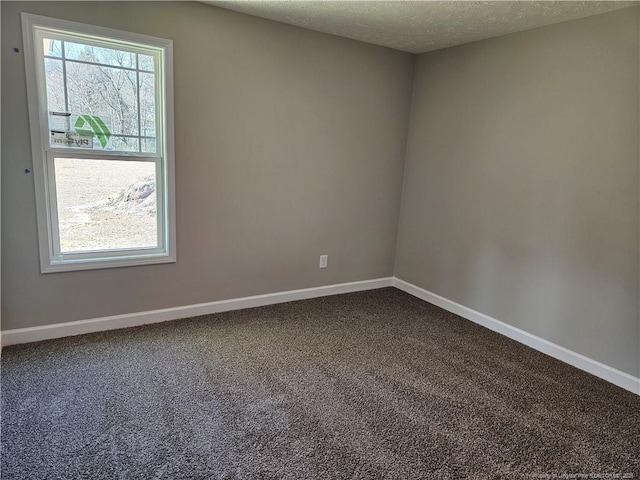 unfurnished room with baseboards, dark colored carpet, and a wealth of natural light