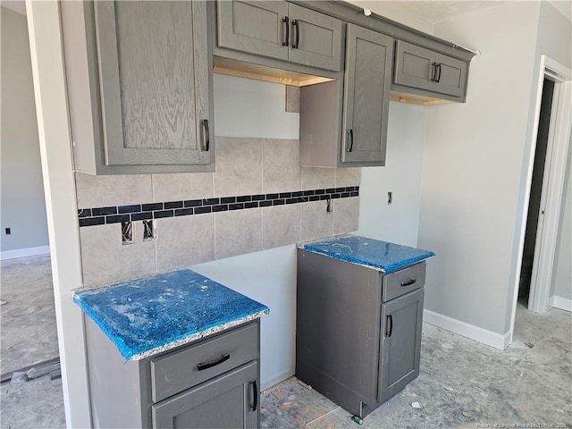 kitchen with decorative backsplash and gray cabinetry