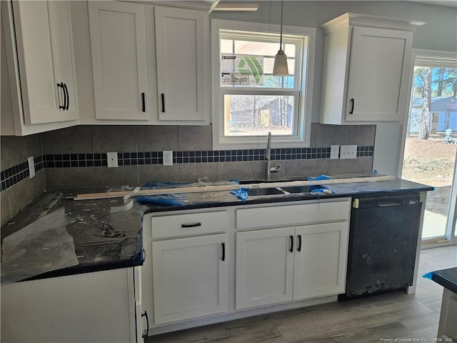 kitchen with tasteful backsplash, black dishwasher, white cabinets, and pendant lighting