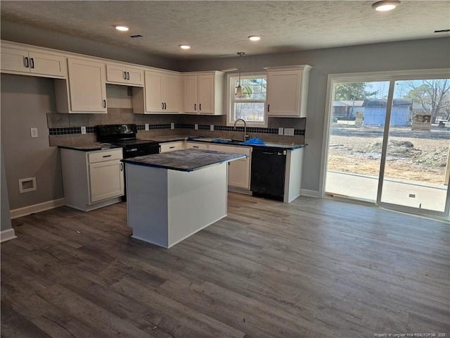 kitchen featuring dark wood finished floors, dark countertops, decorative backsplash, white cabinetry, and black appliances