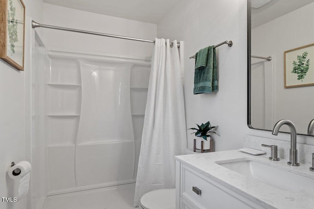 bathroom featuring toilet, walk in shower, and vanity