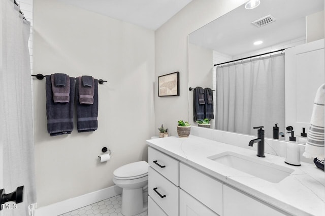 bathroom featuring vanity, tile patterned flooring, and toilet