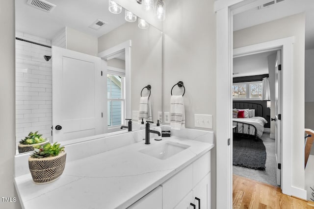 bathroom featuring vanity, hardwood / wood-style flooring, and a baseboard radiator