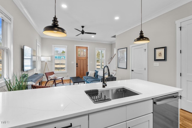 kitchen with sink, pendant lighting, white cabinets, and light stone counters