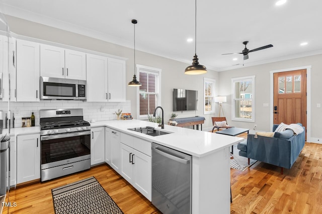 kitchen featuring hanging light fixtures, appliances with stainless steel finishes, and white cabinets