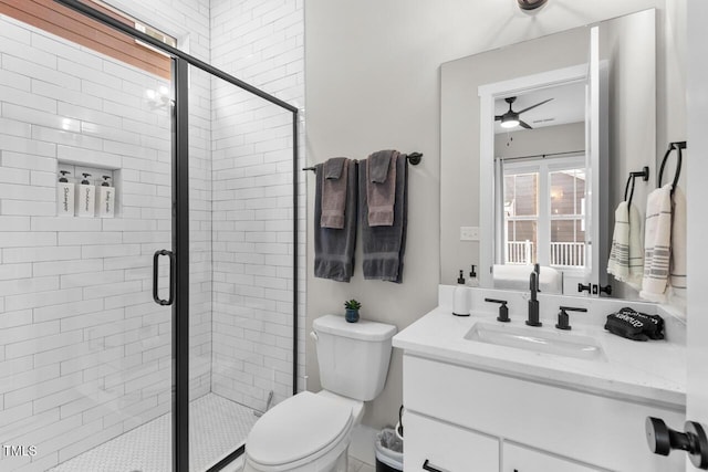 bathroom with vanity, an enclosed shower, toilet, and ceiling fan