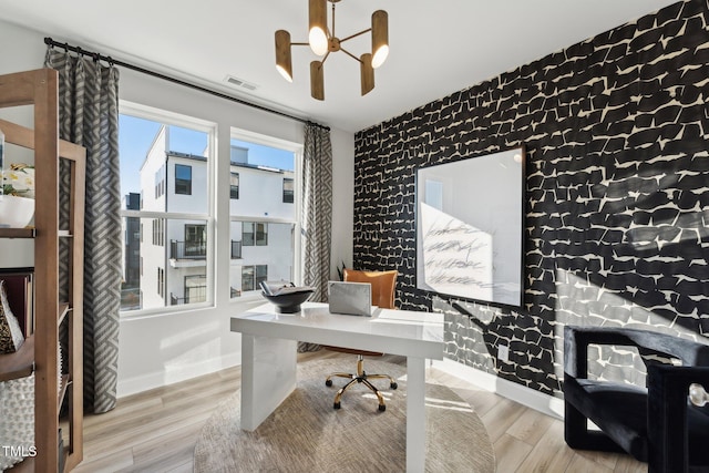 home office with an inviting chandelier and light hardwood / wood-style floors