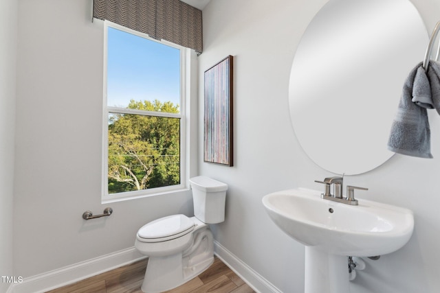 bathroom with toilet, sink, and hardwood / wood-style floors