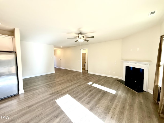 unfurnished living room with ceiling fan and light hardwood / wood-style flooring