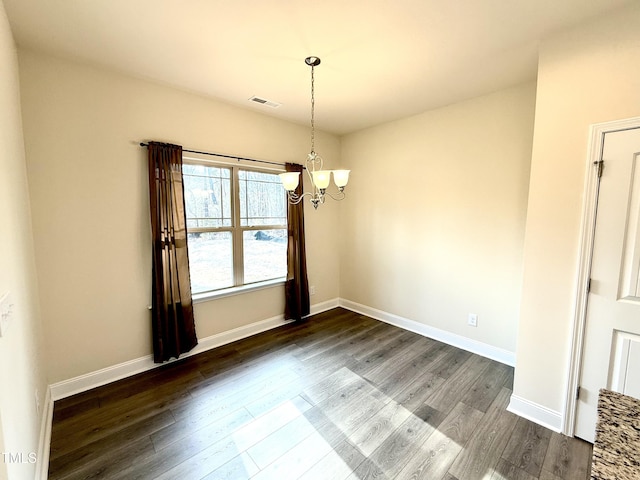 unfurnished dining area with dark wood-type flooring and a notable chandelier