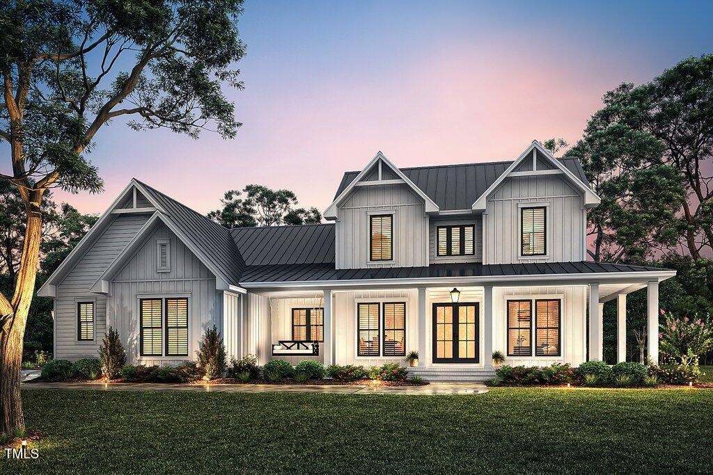 modern farmhouse style home featuring covered porch and a lawn