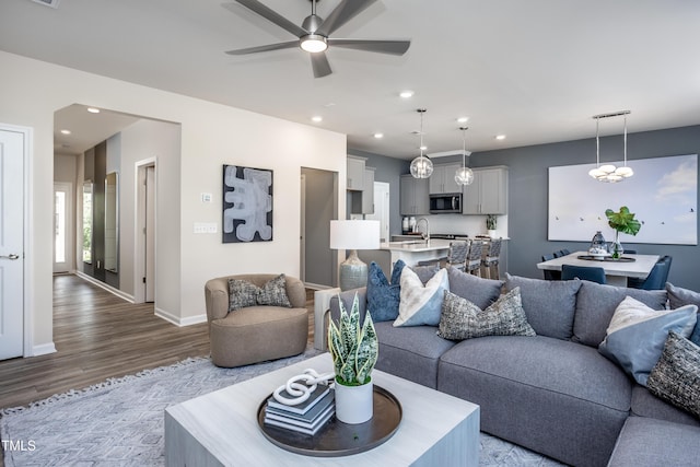 living room featuring ceiling fan and light wood-type flooring