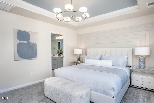 bedroom with a raised ceiling, a chandelier, carpet floors, ornamental molding, and ensuite bathroom