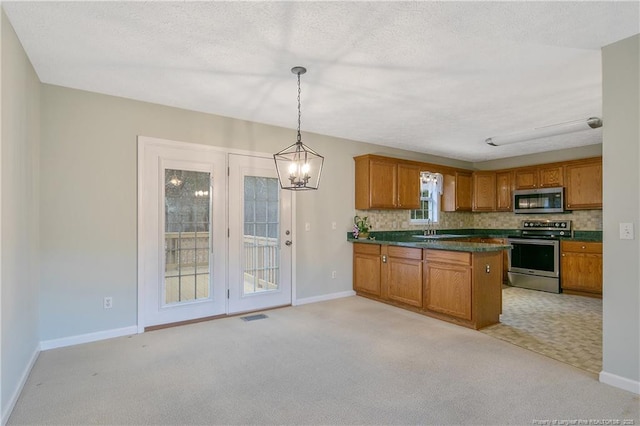 kitchen with stainless steel appliances, backsplash, hanging light fixtures, a chandelier, and light colored carpet