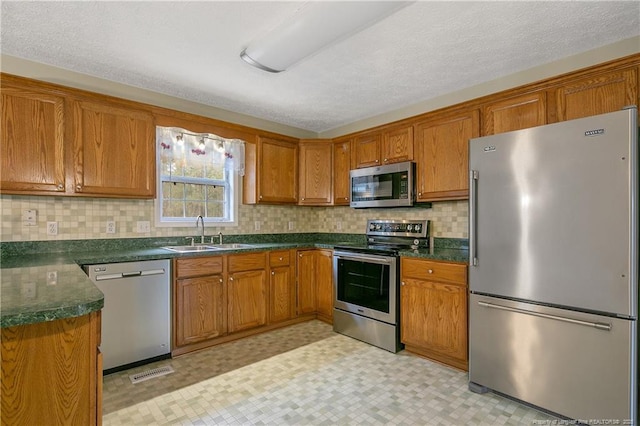 kitchen featuring appliances with stainless steel finishes, decorative backsplash, and sink