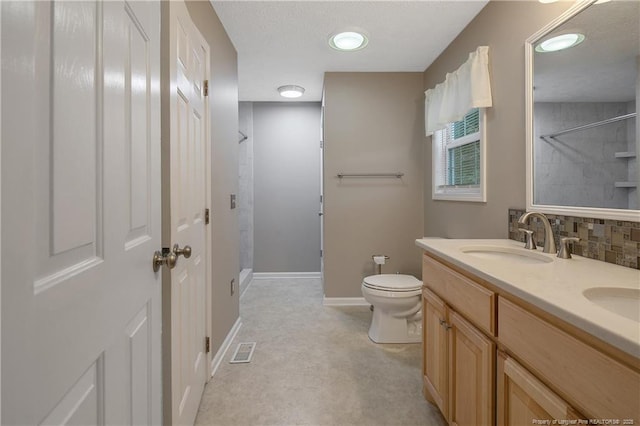 bathroom with toilet, walk in shower, and vanity