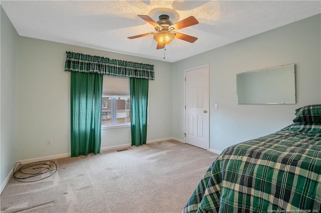 carpeted bedroom with a textured ceiling and ceiling fan