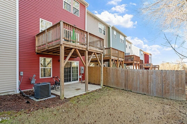 back of property featuring a deck, cooling unit, and a patio