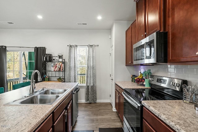 kitchen with dark hardwood / wood-style floors, stainless steel appliances, tasteful backsplash, and sink