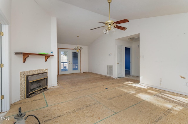 unfurnished living room with vaulted ceiling, ceiling fan, a high end fireplace, and french doors