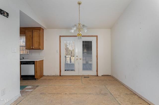 unfurnished dining area featuring lofted ceiling, french doors, plenty of natural light, and an inviting chandelier