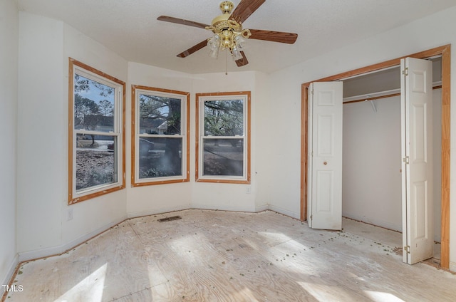 unfurnished bedroom featuring ceiling fan and a closet