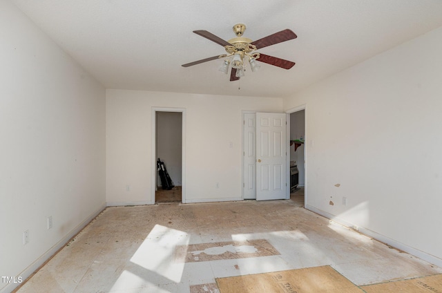 unfurnished bedroom featuring ceiling fan and a walk in closet