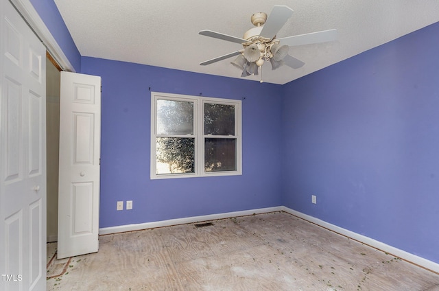 empty room featuring ceiling fan and a textured ceiling