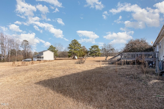 view of yard with a wooden deck and a rural view