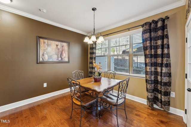 dining space featuring wood-type flooring, ornamental molding, and a chandelier