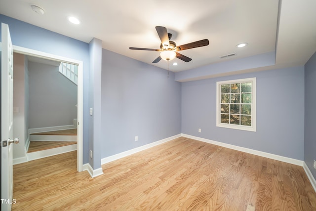 empty room with ceiling fan and light hardwood / wood-style floors