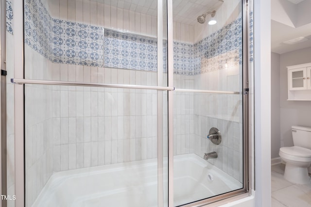 bathroom featuring enclosed tub / shower combo and toilet