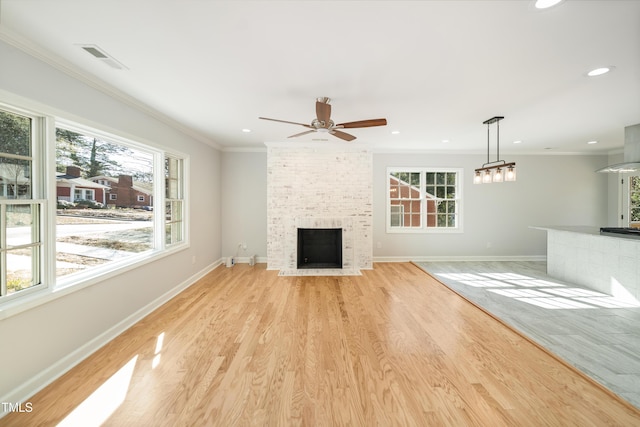 unfurnished living room featuring crown molding, a fireplace, and light hardwood / wood-style flooring