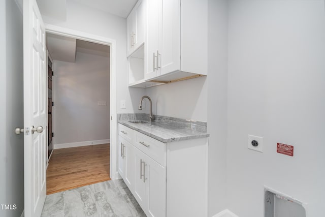 laundry area with cabinets, electric dryer hookup, and sink