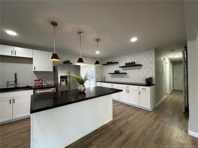 kitchen with pendant lighting, white cabinetry, stainless steel refrigerator with ice dispenser, and sink