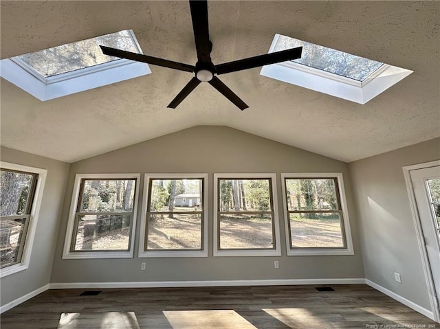 interior space featuring dark wood-type flooring, ceiling fan, and a wealth of natural light