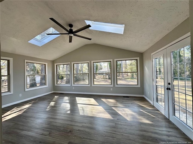 unfurnished sunroom featuring french doors, ceiling fan, and vaulted ceiling with skylight