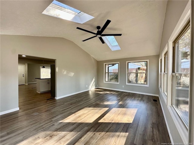 interior space with ceiling fan, lofted ceiling with skylight, and dark hardwood / wood-style floors