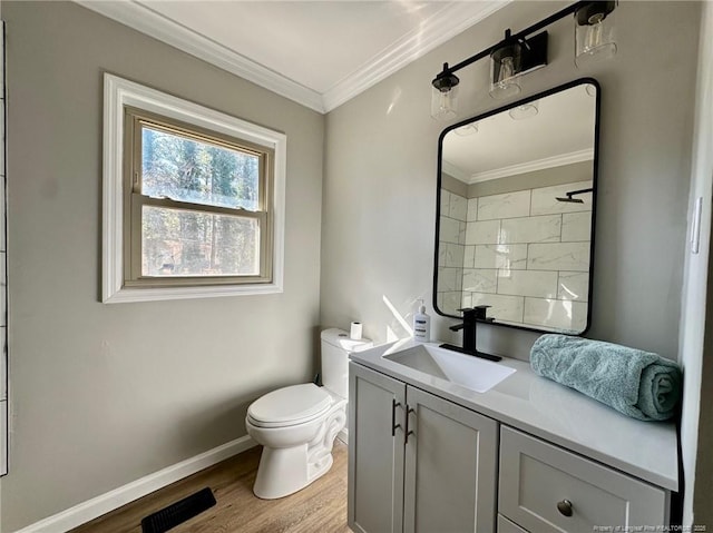 bathroom featuring ornamental molding, toilet, vanity, and wood-type flooring