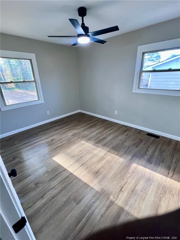 empty room with dark hardwood / wood-style flooring and ceiling fan