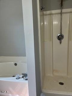 bathroom featuring shower with separate bathtub