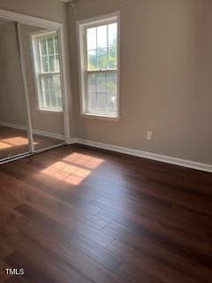 empty room with dark hardwood / wood-style flooring